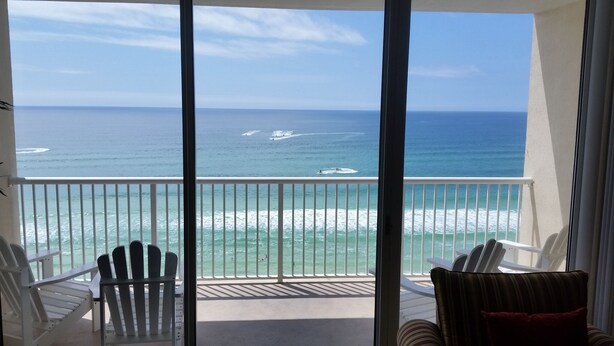 A balcony with a view of the ocean, white chairs, and a table. - GREAT VIEW, FRIENDLY PRICES! (Panama City Beach)