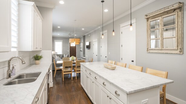 A modern kitchen with a central island, white cabinetry, and pendant lighting. - Downtown in 7min & Rooftop Deck! Gorgeous Stunning Nashville Home!  (Nashville)