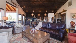 A spacious living area with a leather sofa, a wooden coffee table, and a patterned rug. - 20 acres private ranch with Mountain View’s  (Bend)