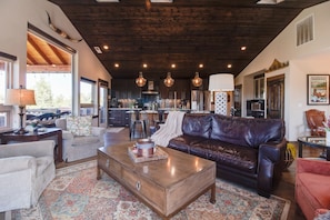 A spacious living area with a leather sofa, a wooden coffee table, and a patterned rug.