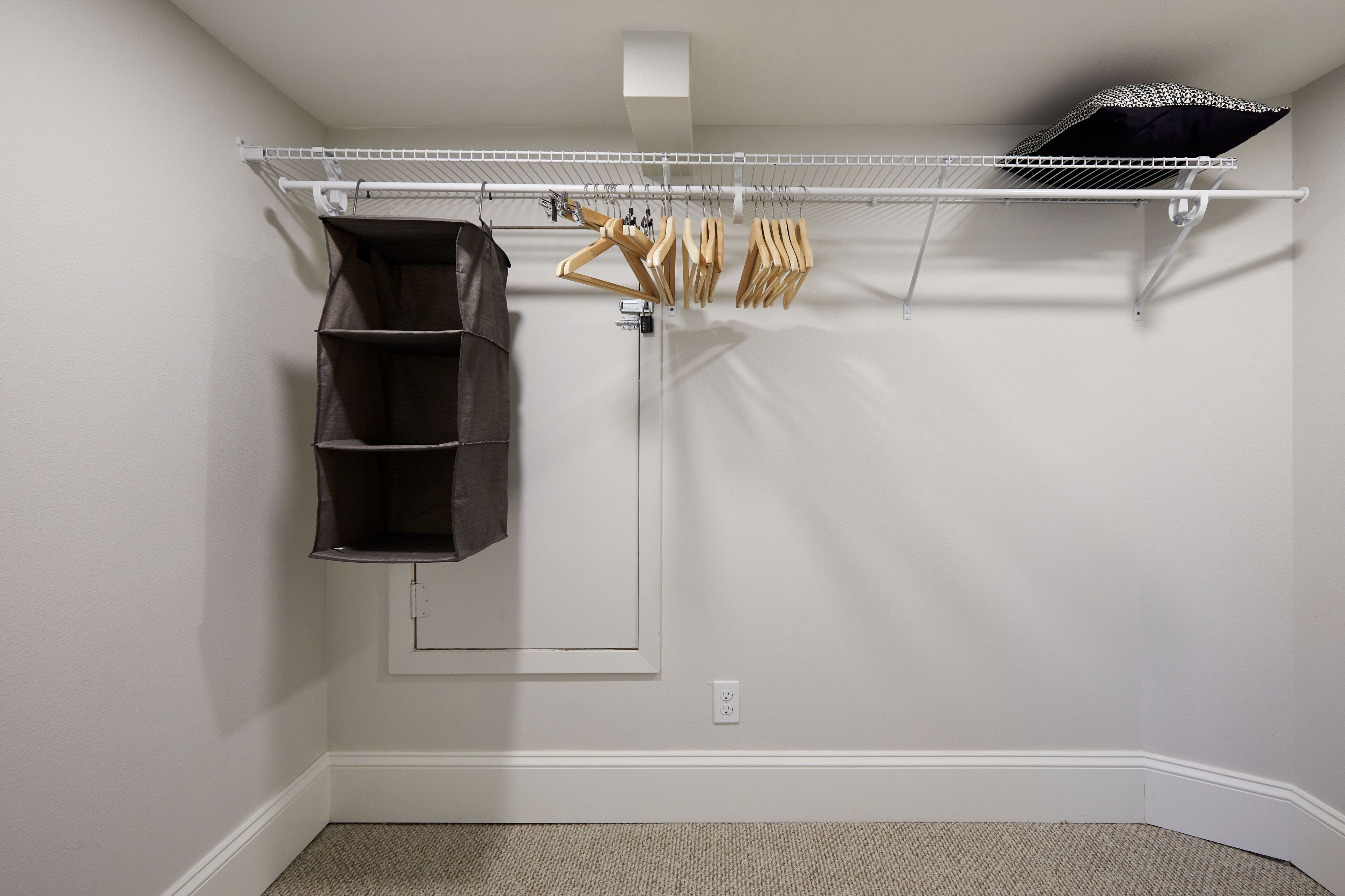 Un placard équipé d’un système de rangement suspendu, d’étagères et d’un porte-chaussures.