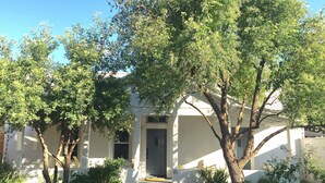 A house with a covered porch, a pathway leading to the entrance, and a well-maintained lawn. - Renovated Adobe One Block From Marfa Courthouse Across From The Hotel Paisano (Marfa)