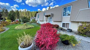 A two-story residential building with a well-maintained lawn and various shrubs. - Premium Theatre Hot-Tub Forest View Home near Whitworth University (Spokane)