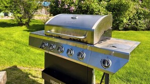 En udendørs grill i rustfrit stål med digitalt display, fire styreknopper og en sideventil.