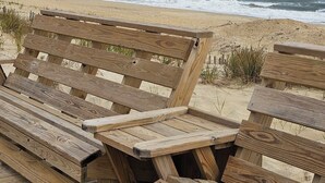 Un espacio con bancos de madera y vista al océano.