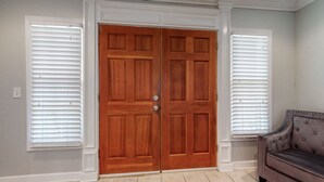 A room with a double wooden door, white trim, and a cushioned bench. -  The Beverly Hills of Nashville, Close to it all! No stairs and a pool table  (Nashville)