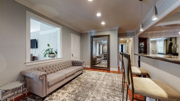 A spacious hallway with a large mirror, a tufted sofa, and a bar area. -  The Beverly Hills of Nashville, Close to it all! No stairs and a pool table  (Nashville)