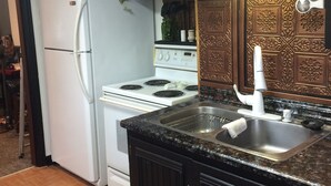 A kitchen with dark wooden cabinets, a white refrigerator, a stove, and a sink with a faucet. - 2 bedroom, 1 bath apartment . Walk to Mayo, trails, parks, shopping, restaurants (Rochester)