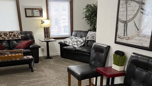 A living room with a sofa, two chairs, a coffee table, a lamp, and a clock on the wall. - 2 bedroom, 1 bath apartment . Walk to Mayo, trails, parks, shopping, restaurants (Rochester)