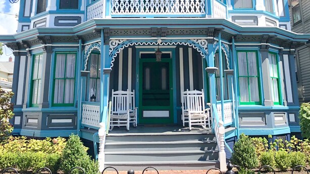 Une maison de style victorien, dotée d’un balcon, d’une porte verte et du numéro « 182 » sur la façade.