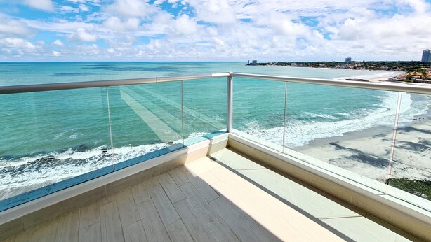 Varanda com vista clara para o oceano e uma linha de costa distante.
