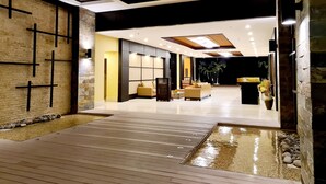 Interior moderno com deck de madeira, área de estar e vista para o exterior.