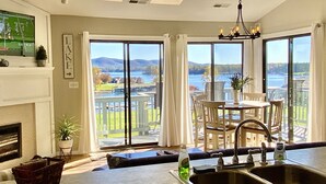 A kitchen with a large window overlooking a lake, a dining area with a table and chairs, and a fireplace. - AUGUST DISCOUNT DAYS BEST VIEWS@BERNARDS LANDING- BOOK NOW (Moneta)