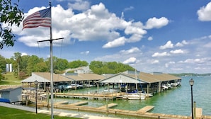 A marina with docked boats, covered structures, and an American flag. - AUGUST DISCOUNT DAYS BEST VIEWS@BERNARDS LANDING- BOOK NOW (Moneta)