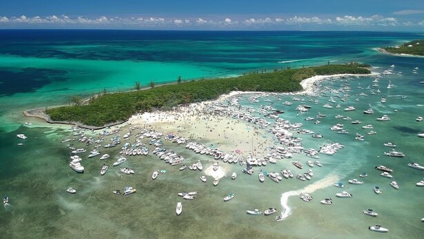 An aerial view of a beach with numerous boats anchored in the water and a large crowd of people on the sand. - Luxury Vacation! The Best of the Best! Ocean Villa Treasure Cay, Bahamas (Treasure Cay)
