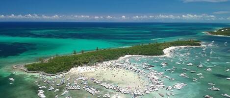 Ranta lähistöllä, aurinkotuoleja, rantapyyhkeitä