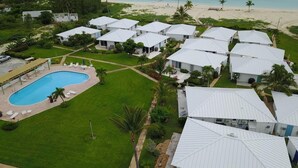A resort with multiple bungalow-style buildings, a swimming pool, and a beach view. - Luxury Vacation! The Best of the Best! Ocean Villa Treasure Cay, Bahamas (Treasure Cay)