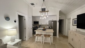 A modern kitchen with white cabinetry, a central island with stools, a built-in oven, and a stainless steel refrigerator. - Luxury Vacation! The Best of the Best! Ocean Villa Treasure Cay, Bahamas (Treasure Cay)