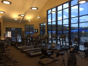 Une salle de sport équipée de tapis de course, de vélos d’appartement et d’appareils de musculation.