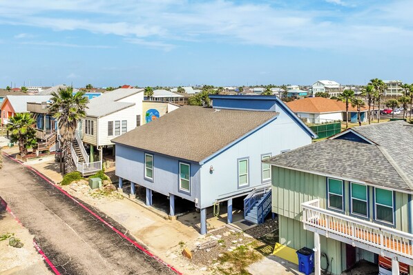 A coastal residential area with houses featuring balconies and a clear sky.