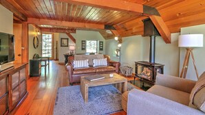 Una sala de estar acogedora con chimenea, sofá de cuero y vigas de madera.