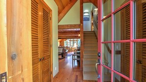 Un interior de madera con una escalera que conduce a un segundo piso, un comedor y una cocina.