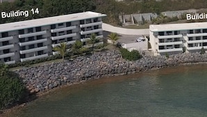 A coastal hotel with multiple buildings, a pool, and a rocky shoreline.