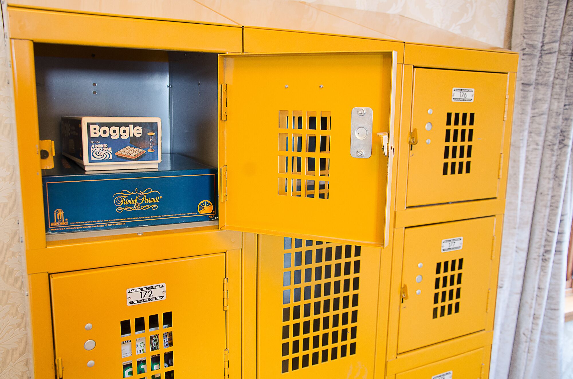 A yellow storage cabinet with multiple compartments, some of which contain labeled items.