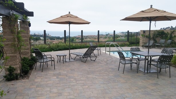 Eine Terrasse mit Sitzgelegenheiten im Freien, einem Pool und Blick auf die Landschaft.