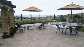 A patio area with outdoor seating, a pool, and a view of the landscape. - Beautiful Beach Condo, A Home Away From Home, Sleeps 6! (Dana Point)