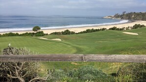 Ein Küsten-Golfplatz mit Sandstrand und Meerblick.