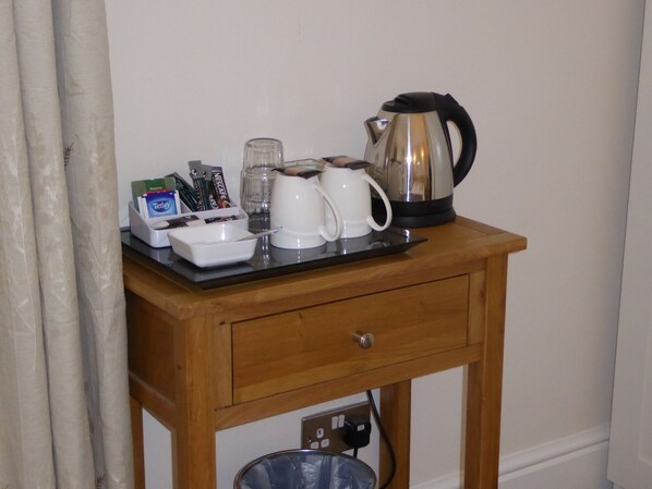 A wooden table with a coffee maker, a white mug, a glass, and a box of tissues. - The Grange Guest House (Brecon)