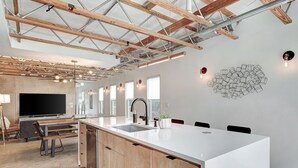 Una cocina moderna con una isla grande, armarios de madera y lavavajillas empotrado.