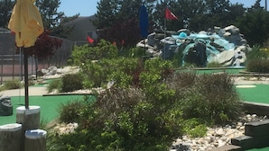A landscaped area with a rock waterfall, green artificial turf, and various plants. - BEST BRIGANTINE VALUE! WE PAY BEACH FEES. WALK TO BEACH, EATERIES. 11AM CHECKOUT (Brigantine)