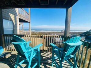 A wooden deck with two turquoise Adirondack chairs facing a wooden railing overlooking a beach and ocean. - Oceanfront SunSational Setting in heart of Duck (Duck)