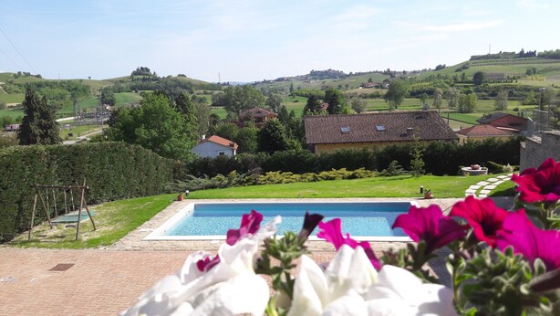 A swimming pool with a view of a rural landscape, including houses and rolling hills. - Villa Sofia Piedmont  (Montaldo Scarampi)