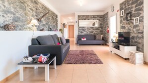 A living room with two sofas, a TV, a small table, and a fireplace. - SUN AND SUN HOUSE (Arco da Calheta)