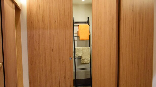 Corredor com portas de madeira dando acesso a um quarto.