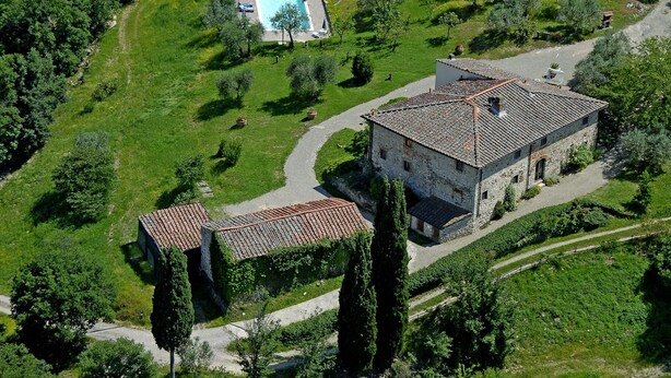 Vue aérienne d’un bâtiment en pierre doté d’une piscine et d’un jardin.