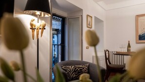 A cozy living room with a modern lamp, a comfortable sofa, a dining table with chairs, and a view of the outside. - Stunning Pantheon View experience in the heart of Rome (Roma)