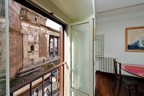 Una habitación con vistas a un edificio histórico, un radiador, una silla y una mesa.