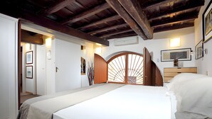 A bedroom with a bed, a wooden door, and a wall-mounted air conditioning unit. - Dalí, charming and modern ground floor loft (Roma)