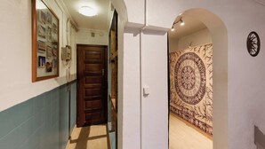 Ein Korridor mit einer Holztür, einem Spiegel mit Fotos und einer Wand mit Muster.