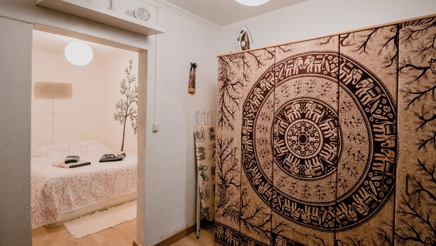 Ein Schlafzimmer mit einem Bett, einer Wandteppich und einem Kleiderschrank.