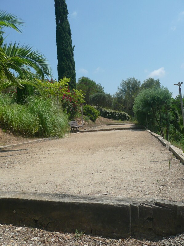 A gravel path with a wooden bench and a stone wall.