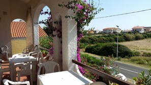Enjoy the view from this balcony with a column and railing, perfect for taking in the sights of the surrounding neighborhood.