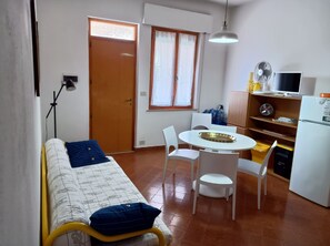 Cozy retreat with a kitchenette, comfortable bed, and a small dining area.
