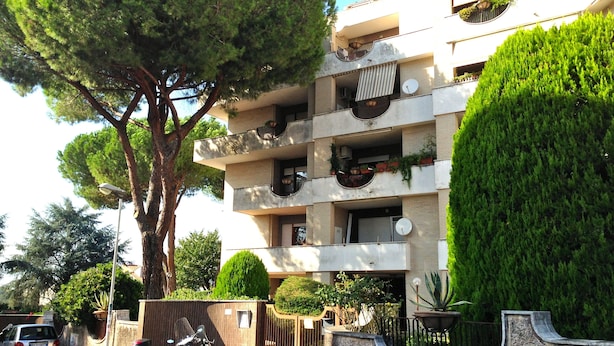 Un edificio a più piani con balconi, alcuni dei quali adornati con piante.