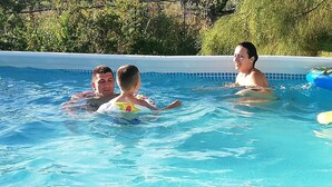 Una piscina con agua azul cristalina, rodeada de vegetación.
