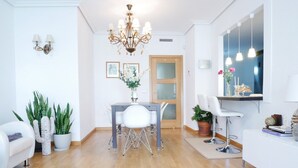 A modern living room with a dining area, a chandelier, and a TV mounted on the wall. - Beautiful, Cosy, Great Apartment Downtown, Near Beach.  Ask for Parking. (Alicante)